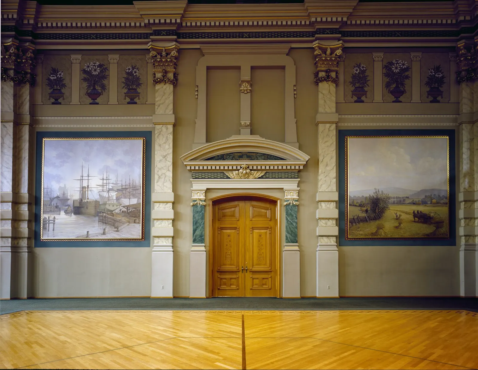 The Milwaukee Grain Exchange trading floor: carved wooden doors under an arched pediment, flanked by two large murals of a harbor and a harvest field.