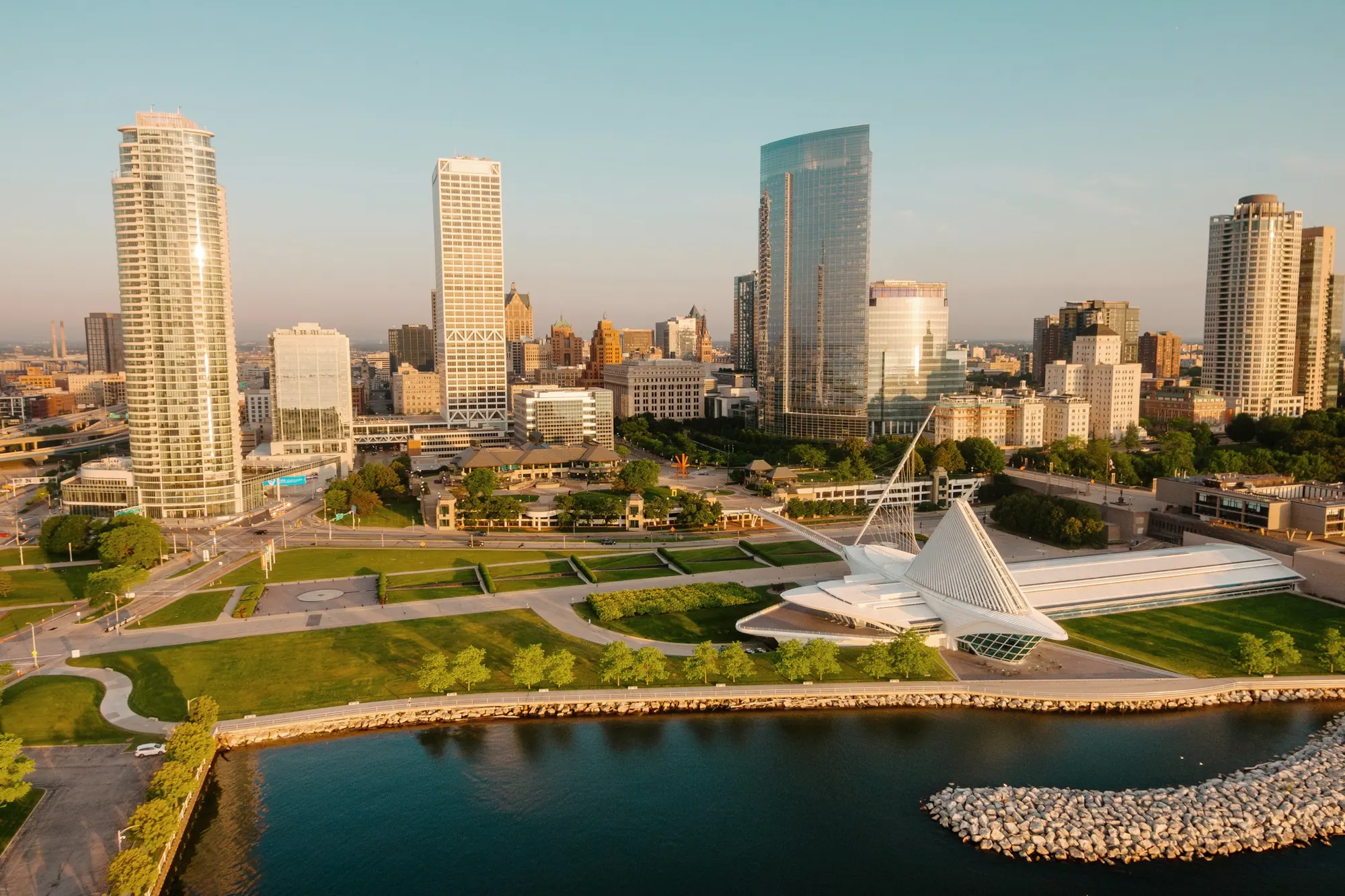 Downtown Milwaukee from above at sunrise, with the lakefront and Lake Michigan in the foreground.